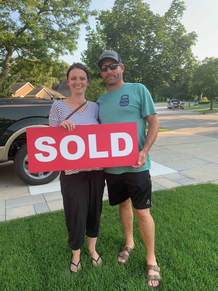 Realtor Mary Ellen Weatherhead celebrating property sale with clients.